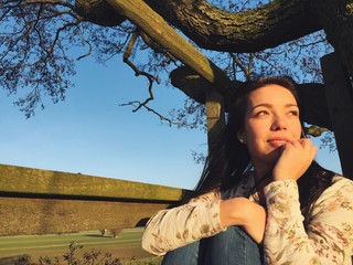 junge Frau schaut Richtung Sonne