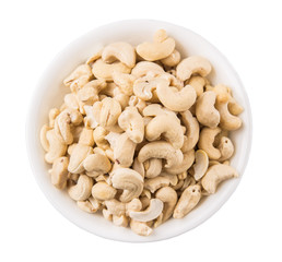 Raw cashew nuts in a white bowl over white background