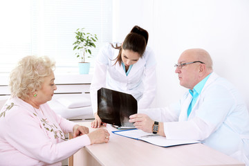 Obraz premium Happy doctors and patient in hospital clinic