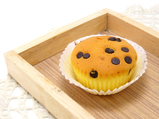 cupcake topping with chocolate ships on wooden tray