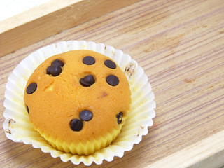 cupcake topping with chocolate ships on wooden tray