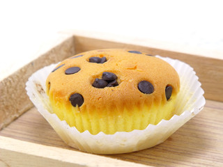 cupcake topping with chocolate ships on wooden tray