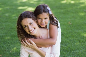 Happy mother and daughter smiling at camera