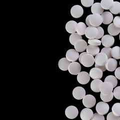 White pills on black