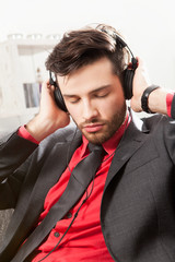 Mann im Anzug hört Musik mit Kopfhörern