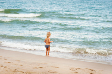 little girl looks at the sea