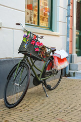 Fototapeta na wymiar Bicycle stands near wall on the street in Dutch city