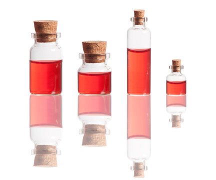 red liquid in bottles with cork isolated on white background