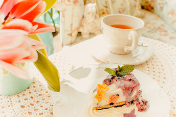 Sweet cupcake with cup of tea on the table in sunny day