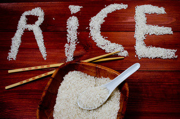 Rice on wooden table with chopsticks - obrazy, fototapety, plakaty