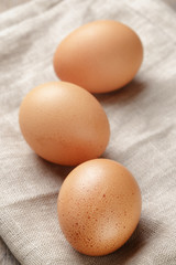 whole raw brown eggs closeup on wood table