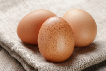 whole raw brown eggs closeup on wood table