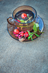 Autumn tea in black glass cup on old rustic linen napkin
