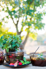 Autumn tea in black glass cup on old rustic linen napkin