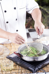 Chef scald vegetable in pot before cooking noodle