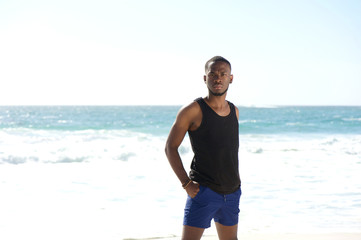 Handsome young african american man standing at the beach