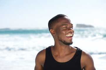 Handsome young african american man laughing at the beach