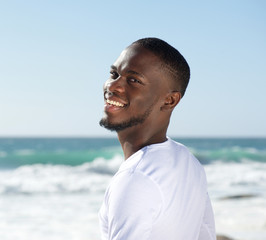 Happy smiling cheerful young man at the beach