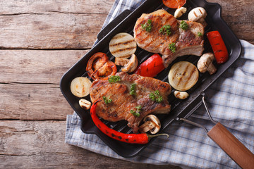 Grilled meat with mushrooms in a pan grill. horizontal top view