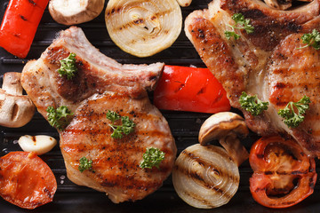 Pork steak grilled with onions and tomatoes. horizontal top view