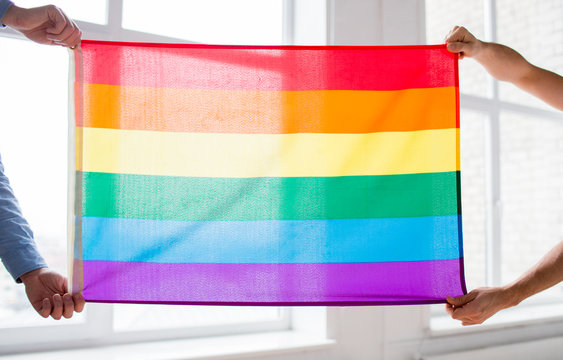 Close Up Of Male Gay Couple Holding Rainbow Flag