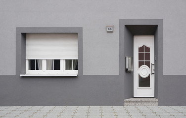 Renovierte Altbaufassade in grau mit PVC Haustür und Fenster