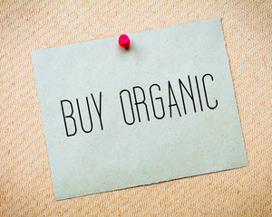 Recycled paper note pinned on cork board.Buy Organic Message