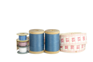 spools of thread with a ruler isolated over white