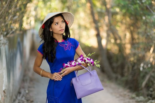 pretty young Vietnamese woman carrying flowers