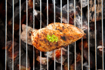 Marinated grilled chicken on the flaming grill