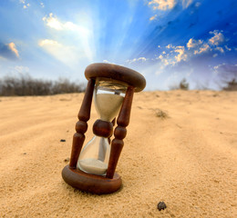 Hourgass in desert on sand