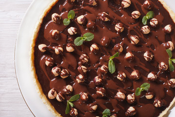 Chocolate tart with hazelnut close-up. horizontal top view