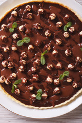 Chocolate tart with hazelnut close-up. vertical top view