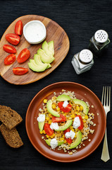 Fototapeta na wymiar salad with quinoa, red lentils, corn, avocado and tomato with yo