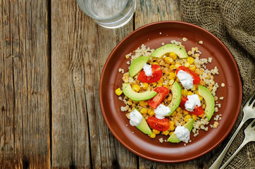 salad with quinoa, red lentils, corn, avocado and tomato with yo