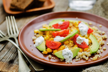 salad with quinoa, red lentils, corn, avocado and tomato with yo