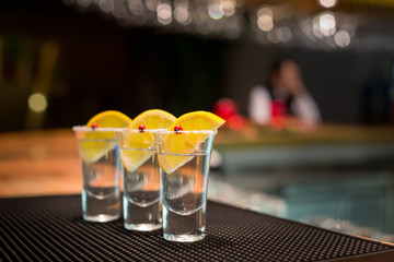 Three tequila shots with lemon