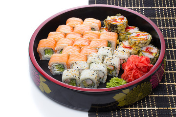 sushi with chopsticks and soy sause over white
