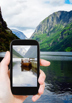 tourist taking photo of fjord in Norway