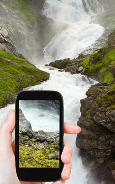 tourist taking photo of kjosfossen waterfall