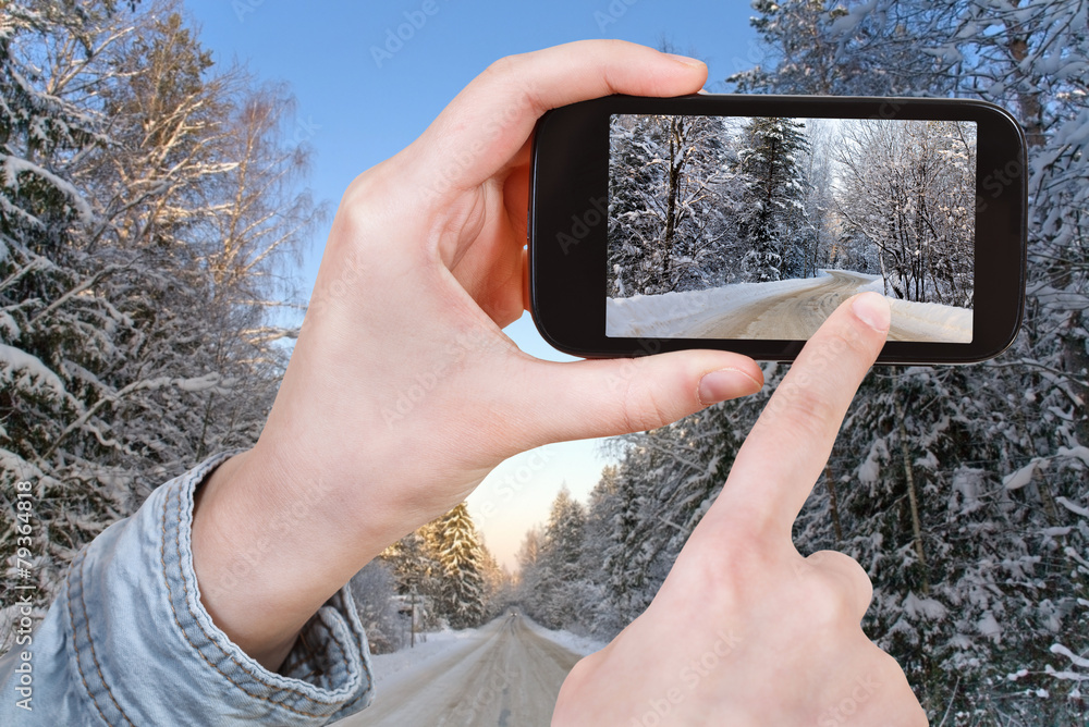 Sticker tourist taking photo of winter road in snow forest