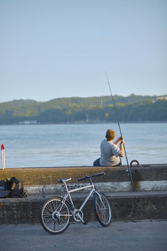 Red headed boy with fishing pole and silver bicycle