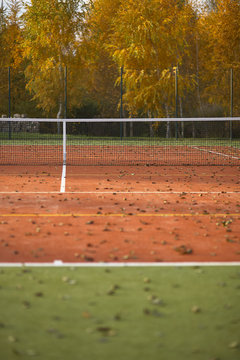 Empty tennis court covered with leaves
