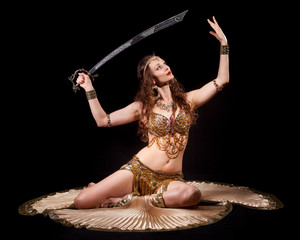 Beautiful belly dancer holding sword up