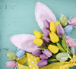 Easter bunny ears on aqua blue wood table.