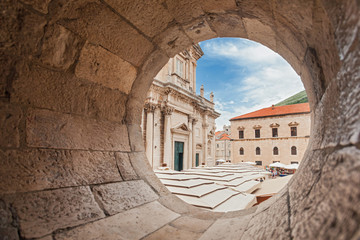 DUBROVNIK, CROATIA - MAY 26, 2014: View on The Assumption Cathedral entrance through circular stone...