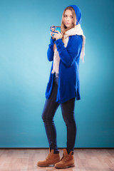 teen girl holding blue mug with hot drink