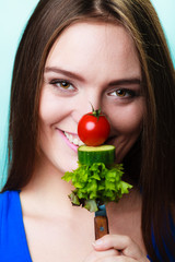 woman holding fork with vegetables