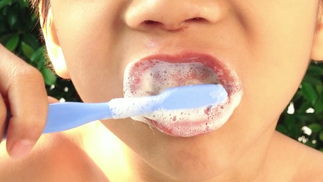 Close up boy with perfect teeth brushing
