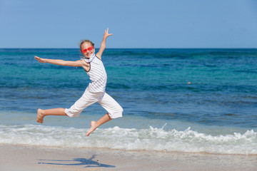 teen girl  jumping on the beach at blue sea shore